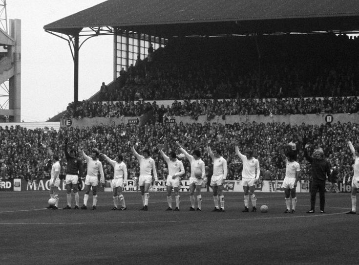 Historic Leeds United line-up on the pitch in front of the stand.