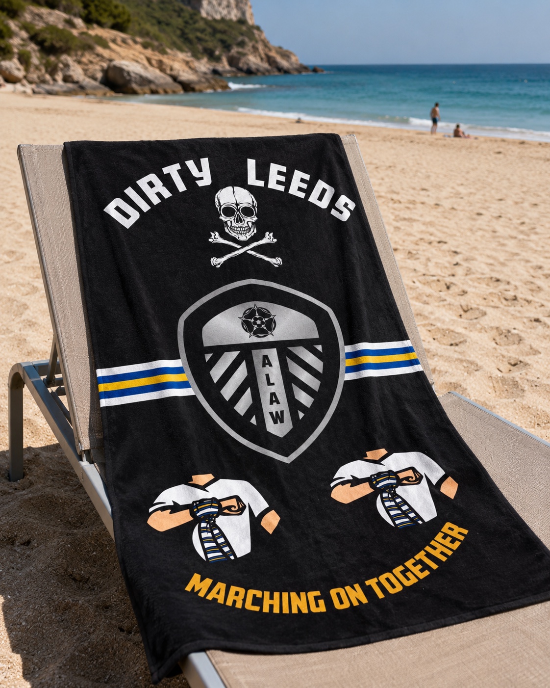 Black Dirty Leeds® ALAW MOT beach towel laid out on a sunbed by the sea.