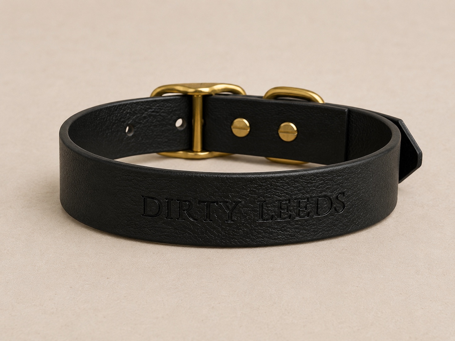 Reverse view of the Dirty Leeds® black dog collar showing the embossed DIRTY LEEDS lettering.