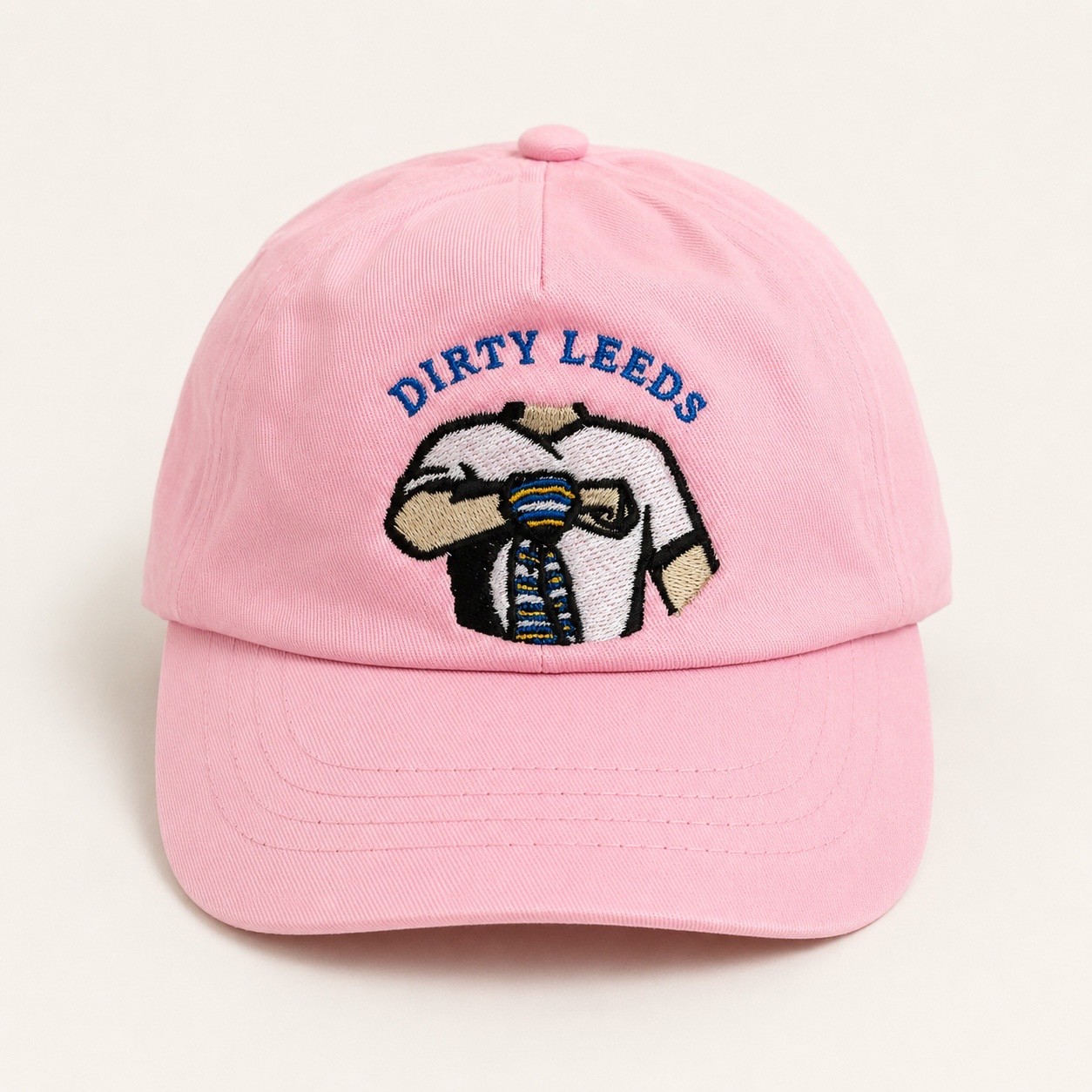 Front view of the light pink Dirty Leeds® Original Logo Junior Baseball Cap with embroidered Keep Fighting salute logo and curved peak.