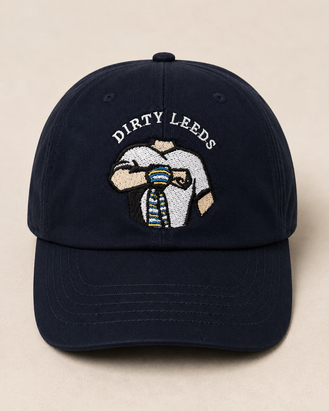 Front view of the navy Dirty Leeds® Original Logo Junior Baseball Cap with embroidered Keep Fighting salute logo and curved peak.