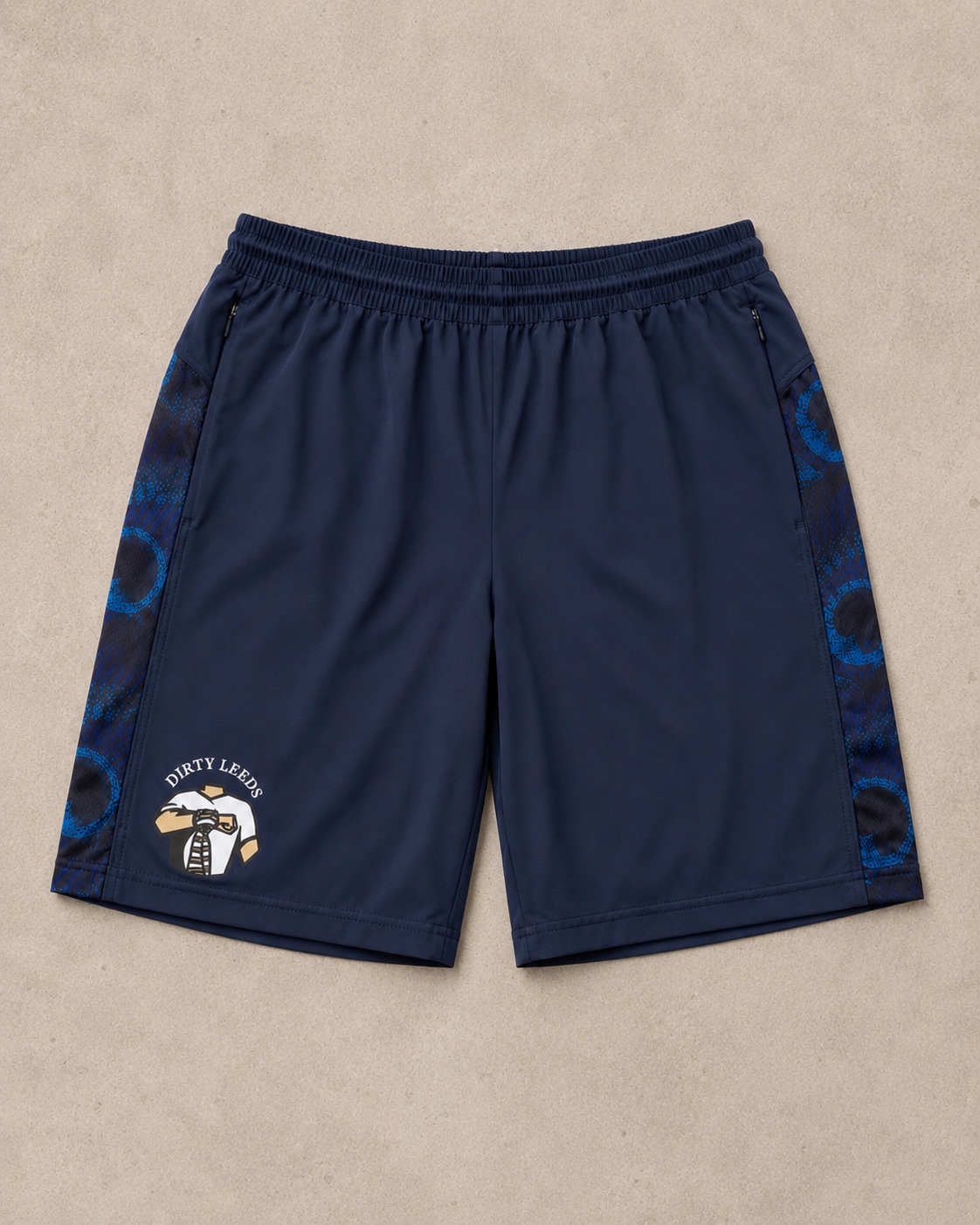 Front view of the Dirty Leeds® Peacock Pattern Shorts in navy with blue peacock side panels and the Dirty Leeds logo on the lower leg.