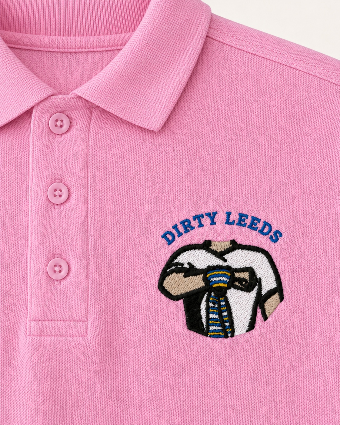 Dirty Leeds® Pink Embroidered Polo Shirt – front view, detail close-up.