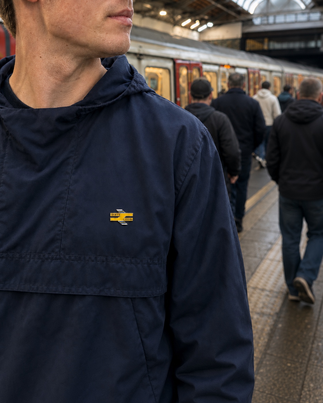 Dirty Leeds Trainlines enamel pin badge worn on a navy smock.