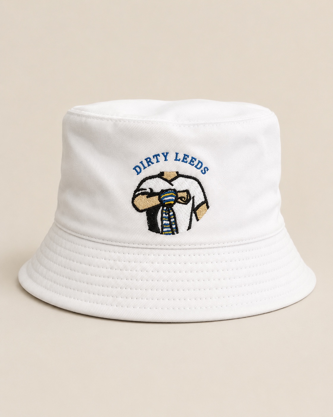 Front view of the Dirty Leeds® White Bucket Hat with blue embroidered Dirty Leeds lettering and scarf salute graphic.