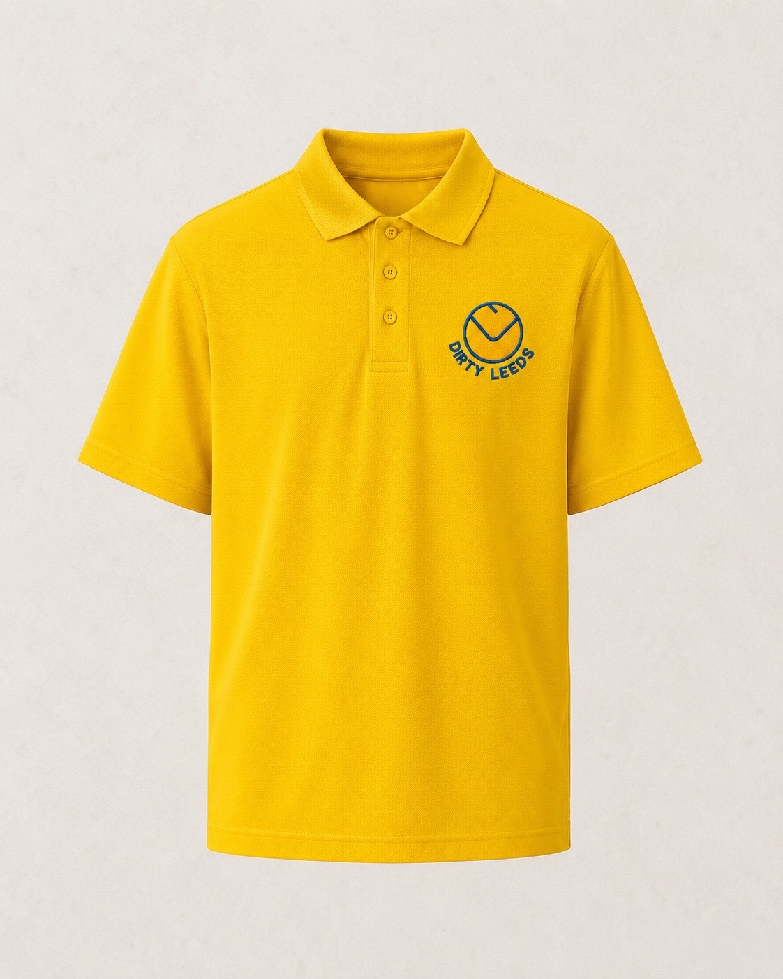 Front view of the Dirty Leeds® Smiley Motif Yellow Polo Shirt with blue smiley embroidery.