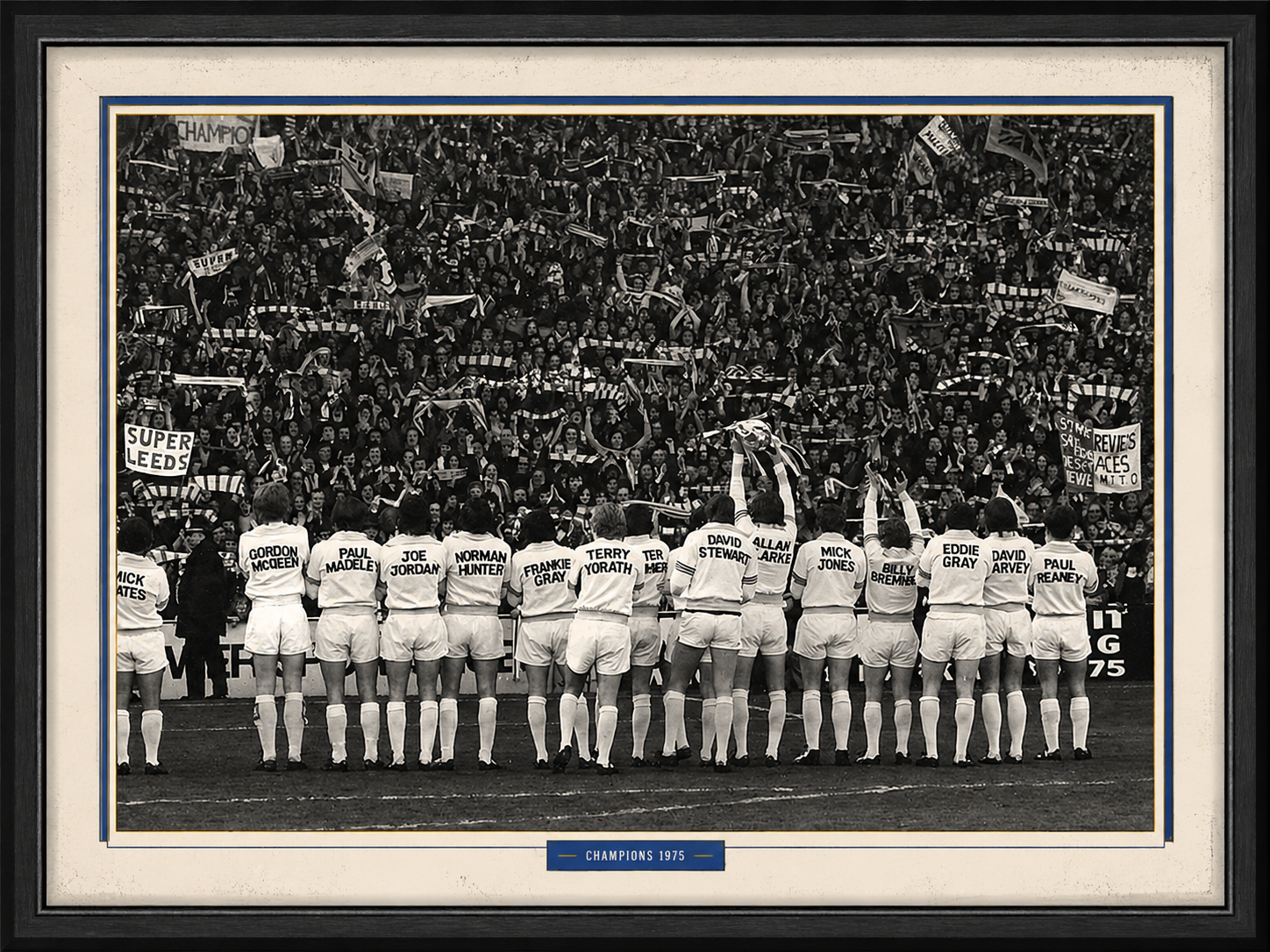 Framed black-and-white photo of the 1975 champions celebrating in front of Leeds supporters.